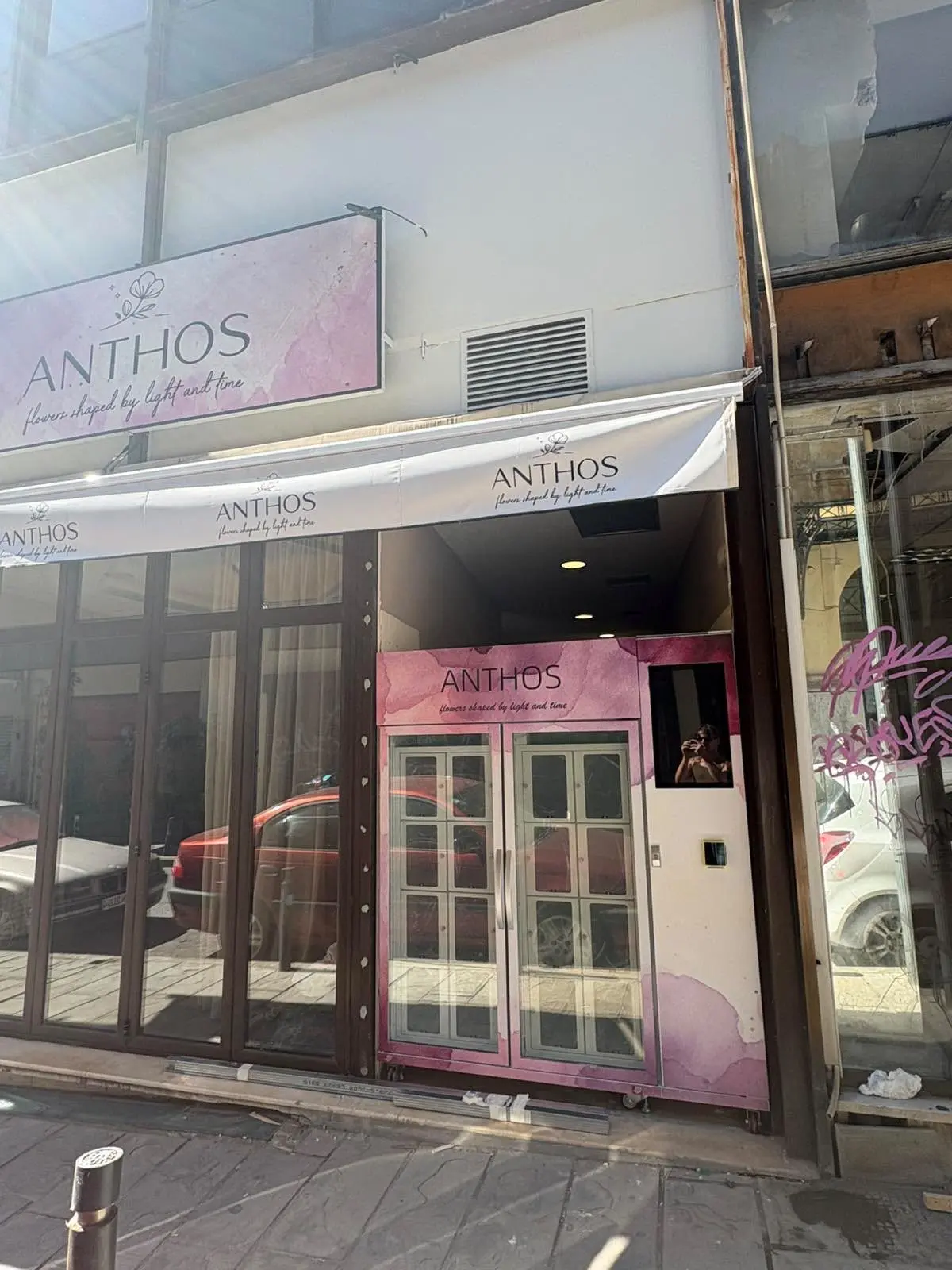 WEIMI refrigerated flower locker cabinet with pink ANTHOS branding beside a flower shop entrance in Greece
